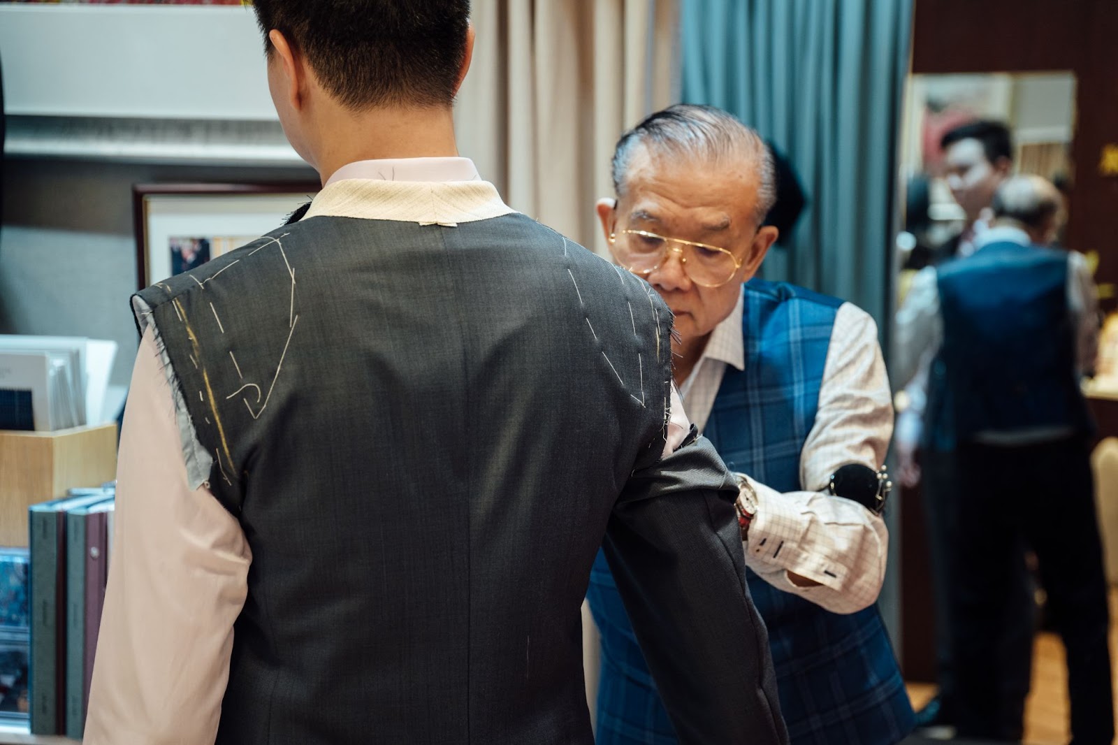 The shop salesperson measuring the customer's chest size