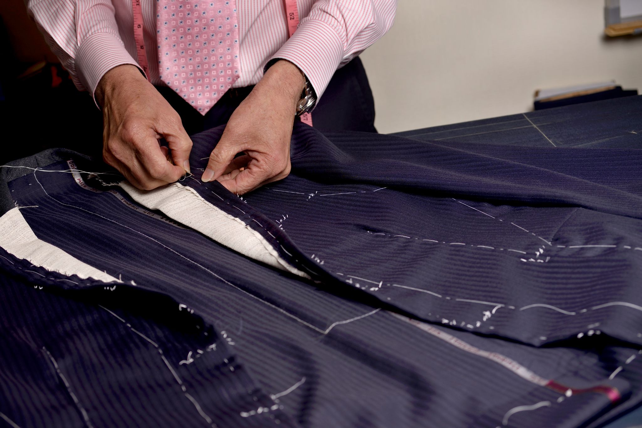 person sewing blue coat